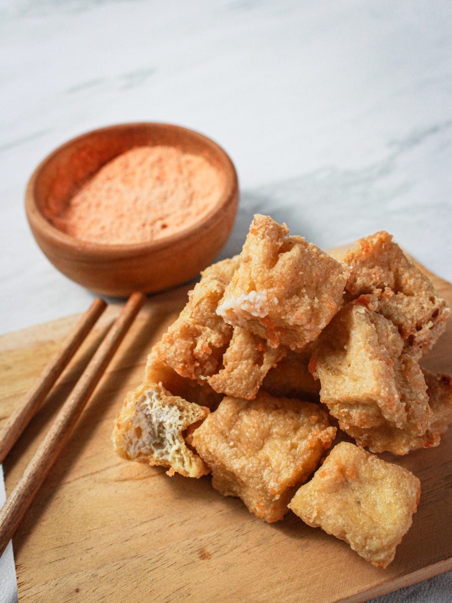 a pile of fried food next to chopsticks on a cutting board