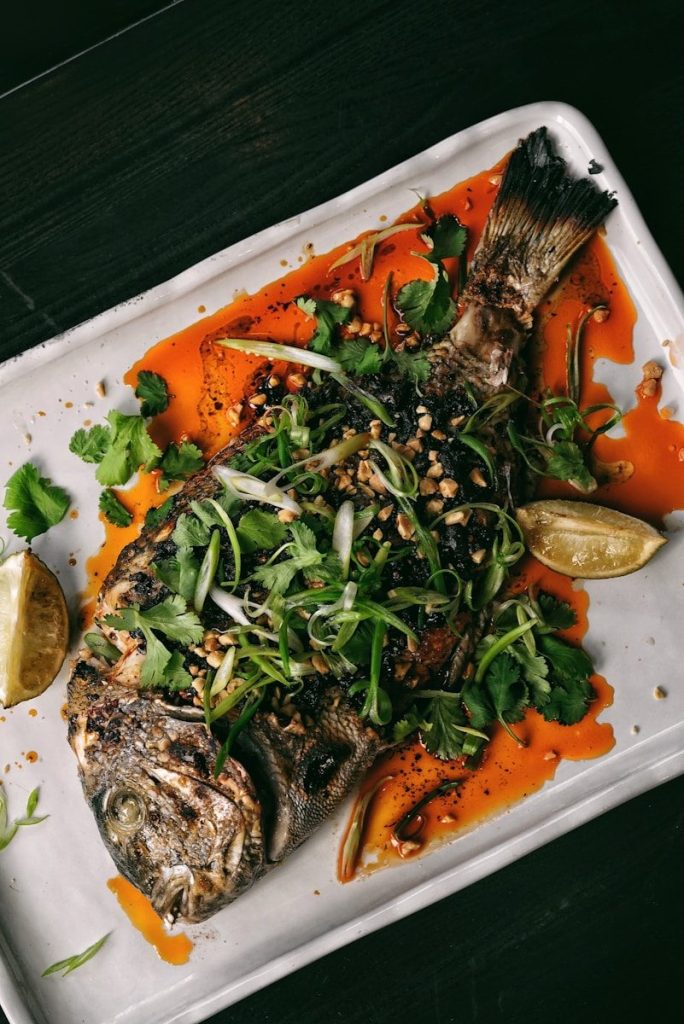 a white plate topped with fish and vegetables